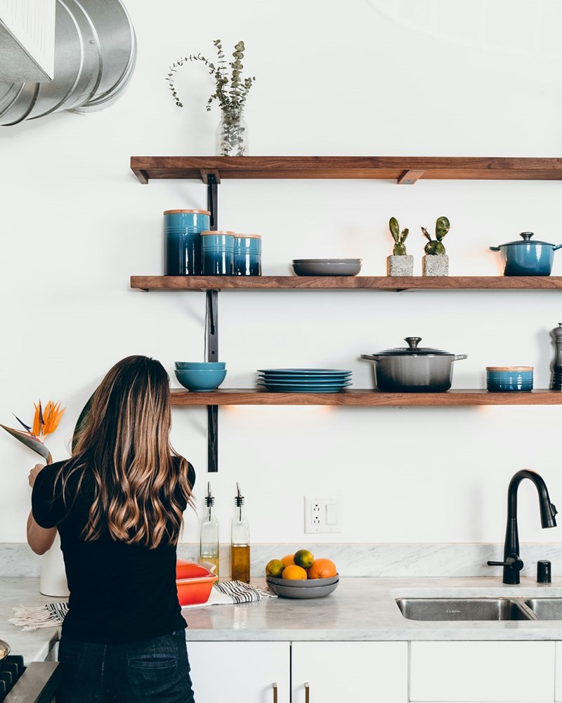 Woman standing in front of kitchen sink.