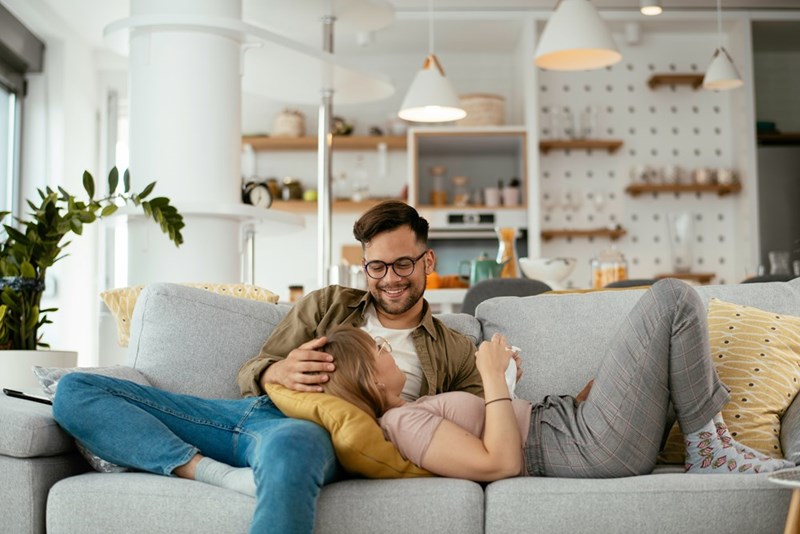 Young couple relaxing together on sofa enjoying calm and affectionate moment