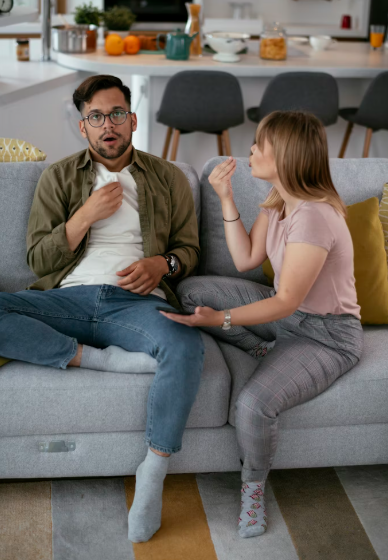 Roommates discussing in the couch casually dressed.