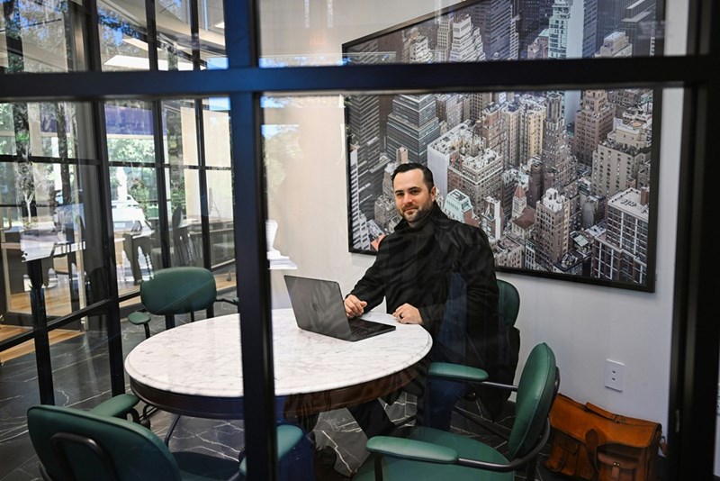 A man works on a laptop in a big meeting room