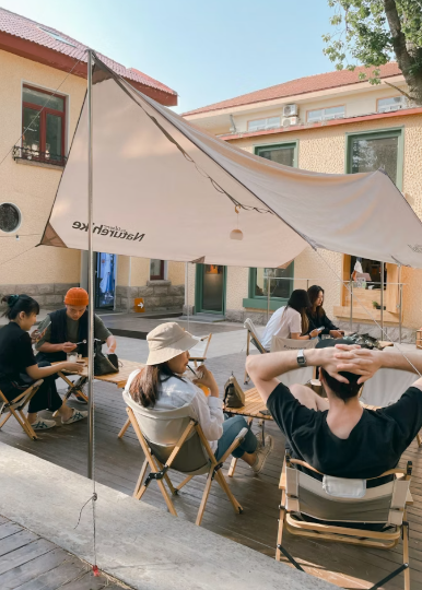 People sitting on folding chairs during daytime in a public area.