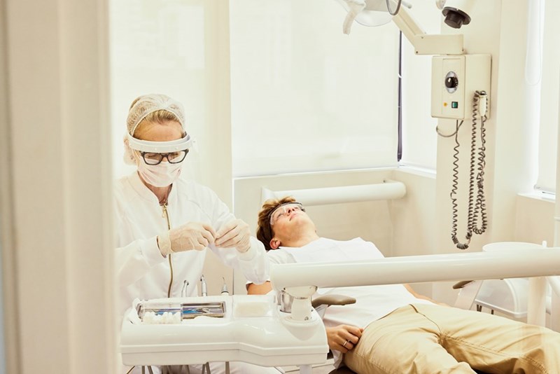 A man sits back in the dentist's chair at his appointment.