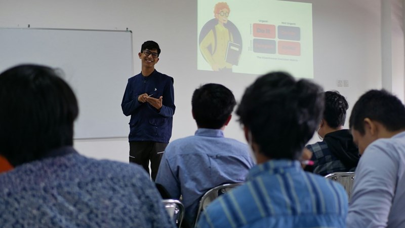 A person gives a seminar to a group of workers in a conference room