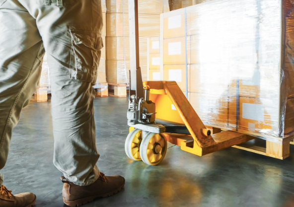 Warehouse worker loading a pallet of heavy wood.