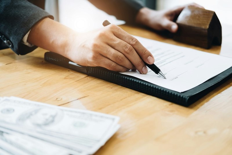 A man signs documents from his landlord