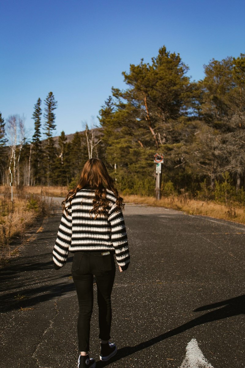 A woman walking to her job interview on the side of the road.