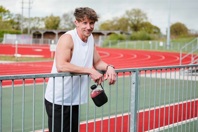Man takes a break from running on an outdoor track.
