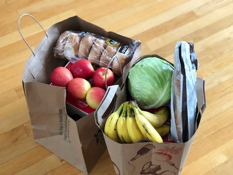 Apples and bananas in brown paper bags