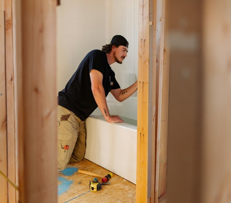 Man working on late-night renovations, making loud noises using a hammer.