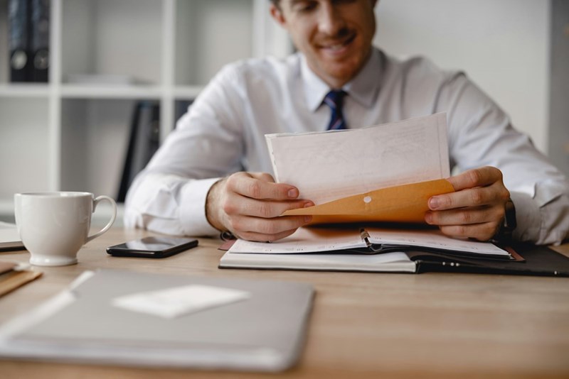 A man sits at a desk preparing documents