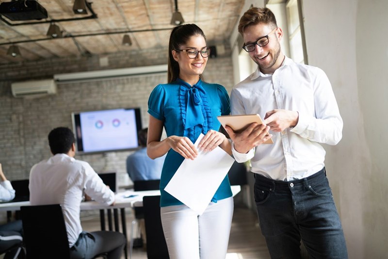 Office worker and his boss laugh together.