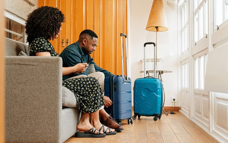 Guests sit on couch after finding the right AirBNB location.