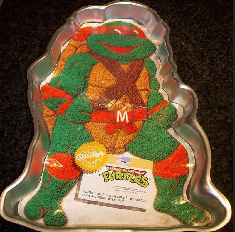 M Wilign TEENAGE MUTANT NINJA TURTLES 01589 1989 Teenage Mutant Ninja Turtles registrademark of Mine Studios, USA Exclusivery Ced by Seg y Sege Long Pan takes any 2-layer cake mix. Suggested tips, colors and instructions on back.