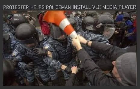 PROTESTER HELPS POLICEMAN INSTALL VLC MEDIA PLAYER PO