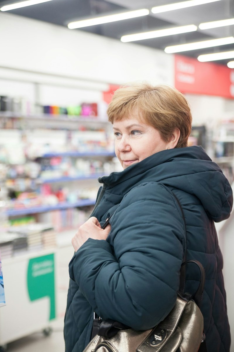 Older woman shopping in an electronics store looking around