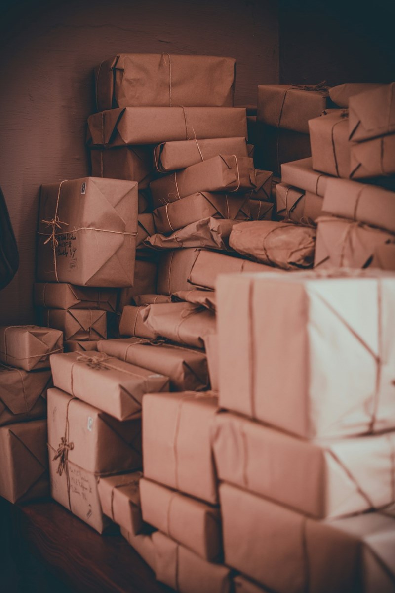 Cardboard mail packages and shipping boxes piled up.