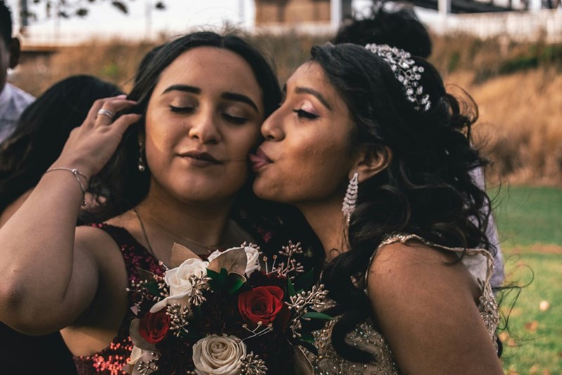 A woman takes a picture with her friend at a wedding