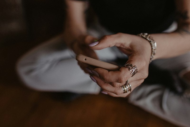 Woman hands filled with rings sending a text message. 