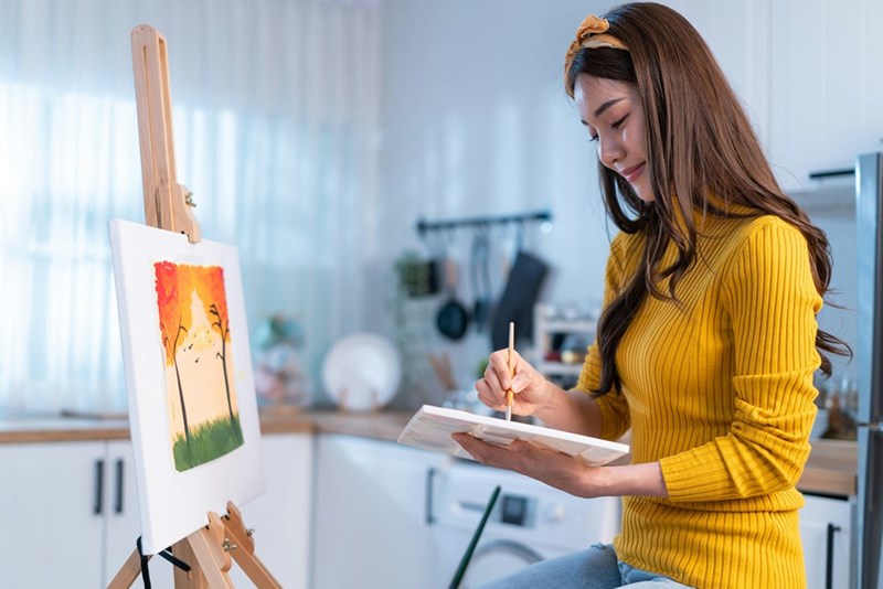 Art student happily paints a picture.