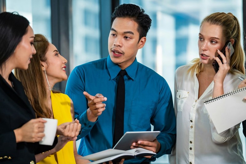 A group of colleagues sharing secrets and spreading rumors at the office.