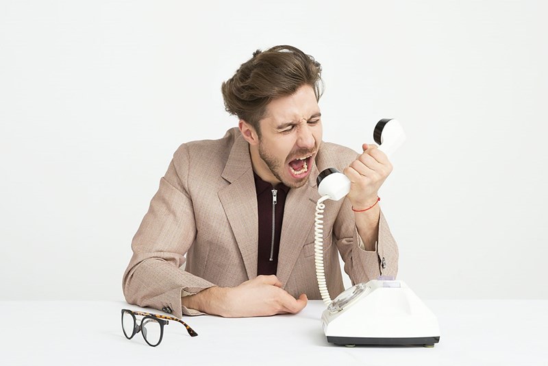 Man holding telephone screaming