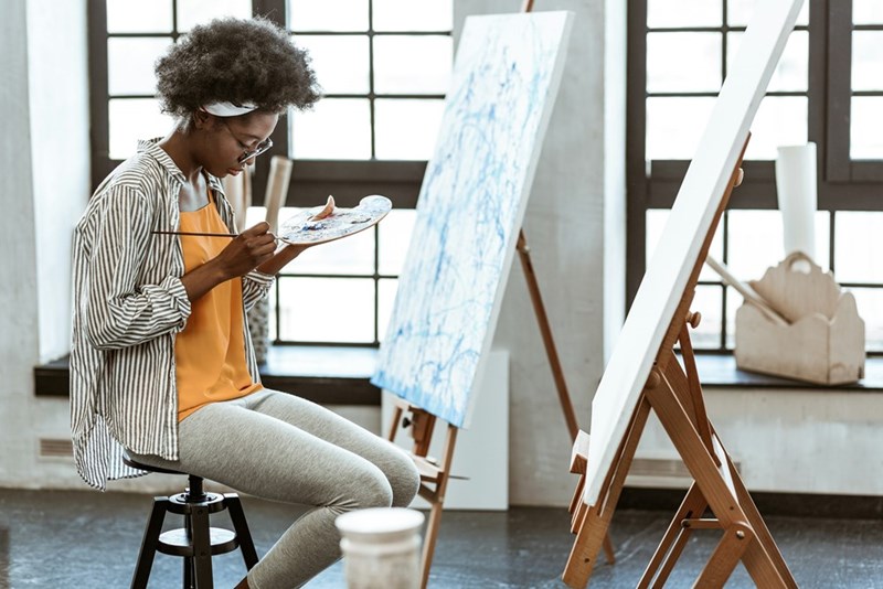 Artist creates painting in art studio.