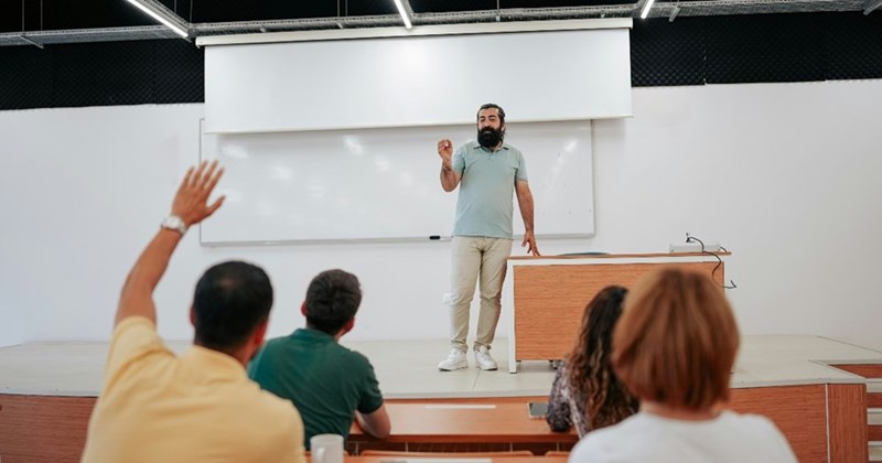 A professor answers a student's question during a classroom lecture.