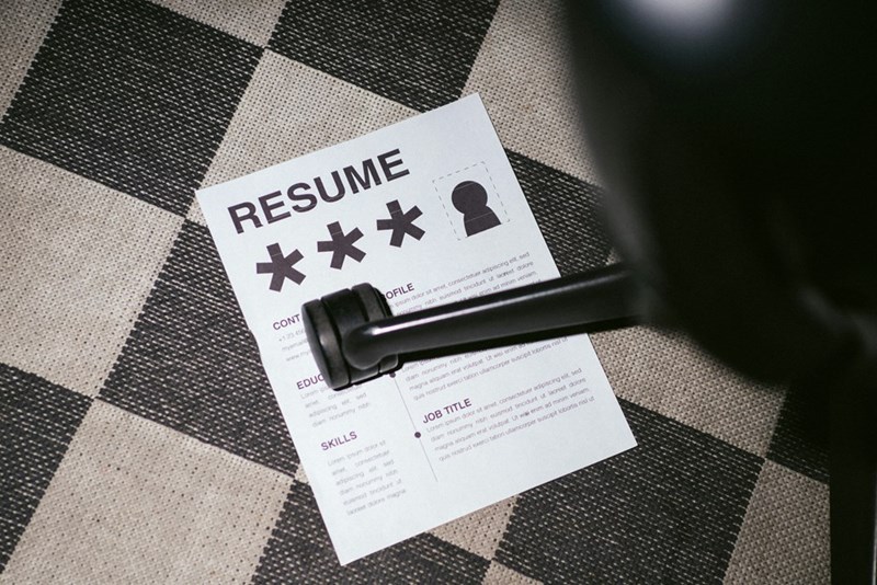 Resume page stuck under the wheels of a rolling chair in an office.