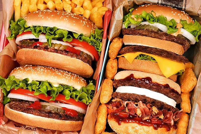 Two trays filled with hamburgers and french fries
