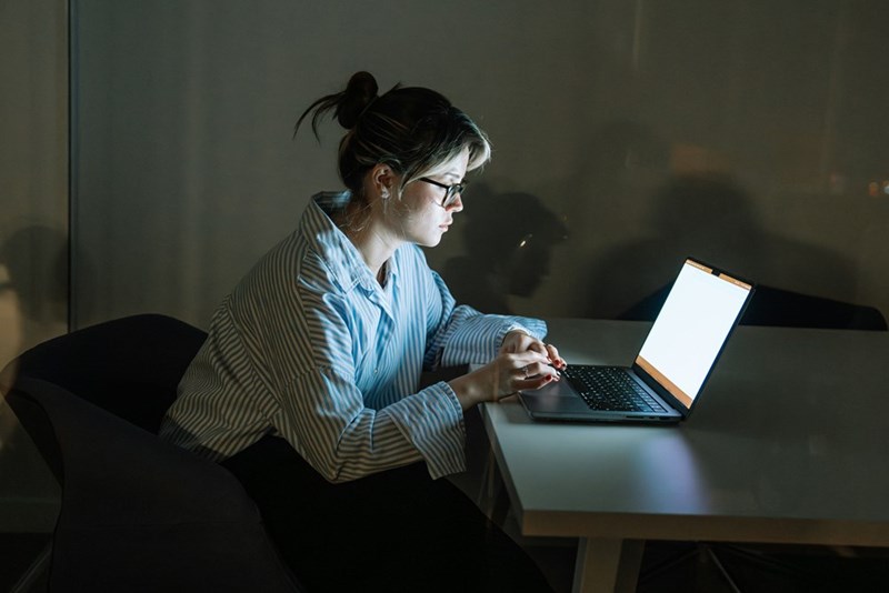 A woman sitting at a desk using a laptop computer