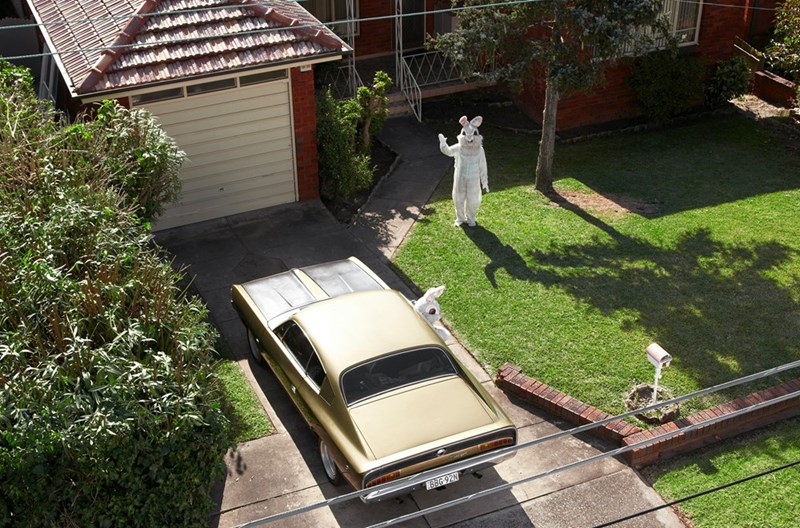 An overhead shot of a parked car in the homeowner's driveway during the day.