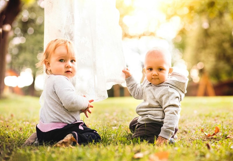 Two babies on the grass in the garden