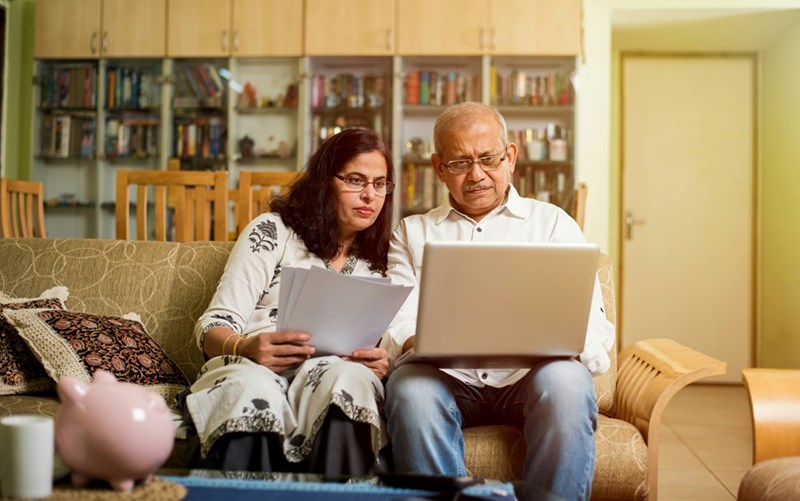 Parents reviewing family budget, treating daughter's savings as part of household finances.