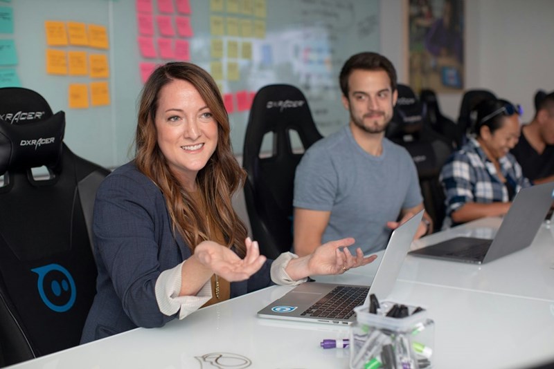 Woman sitting in an office next to other employees
