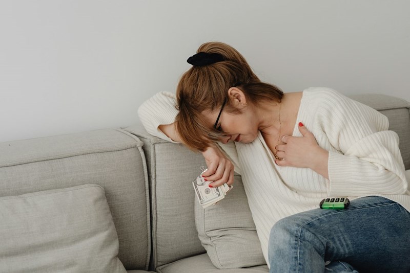 A woman sitting on a couch with her head down