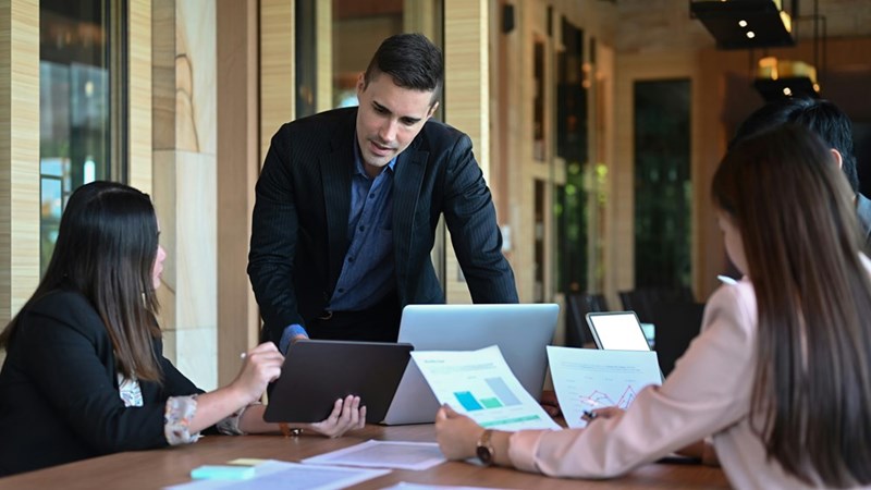 Group of 3 employees work together.