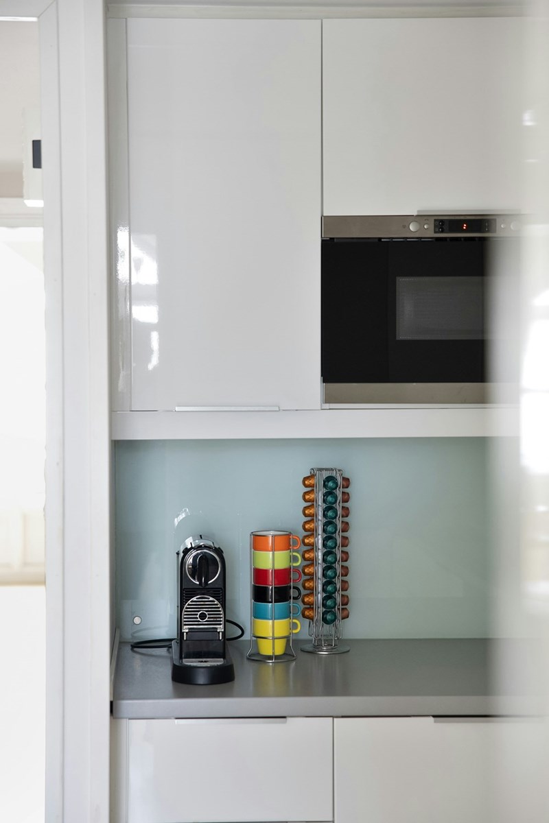 Microwave and coffee mugs in shared office kitchen area