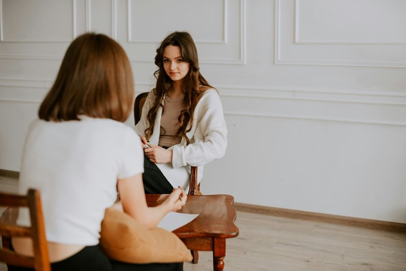A woman sitting on a chair in front of her therapist