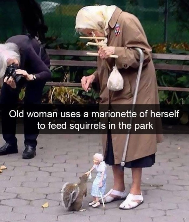 L Old woman uses a marionette of herself to feed squirrels in the park
