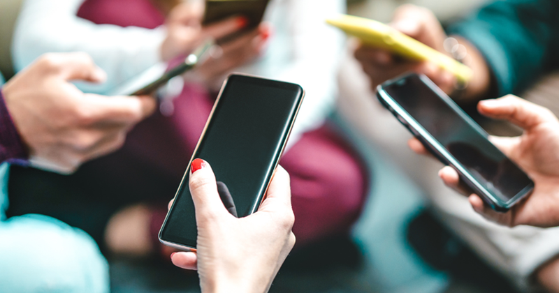 A group of people holding their phones.