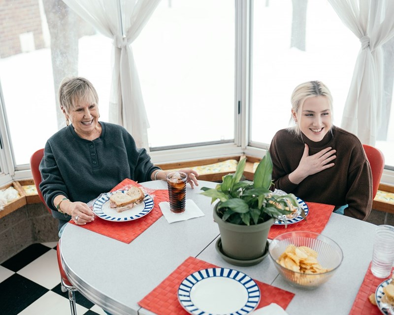 Two people sitting at a table with plates of food