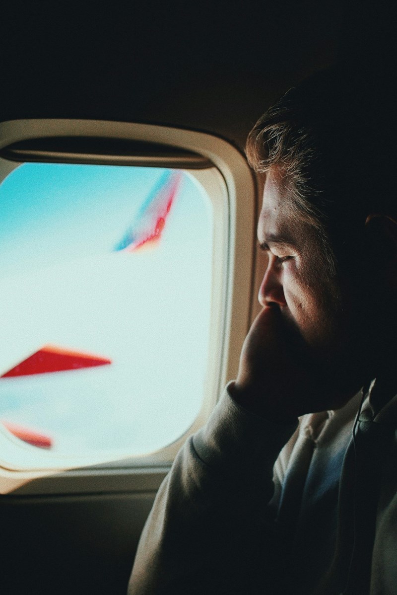 Older man looking out the window of an airplane