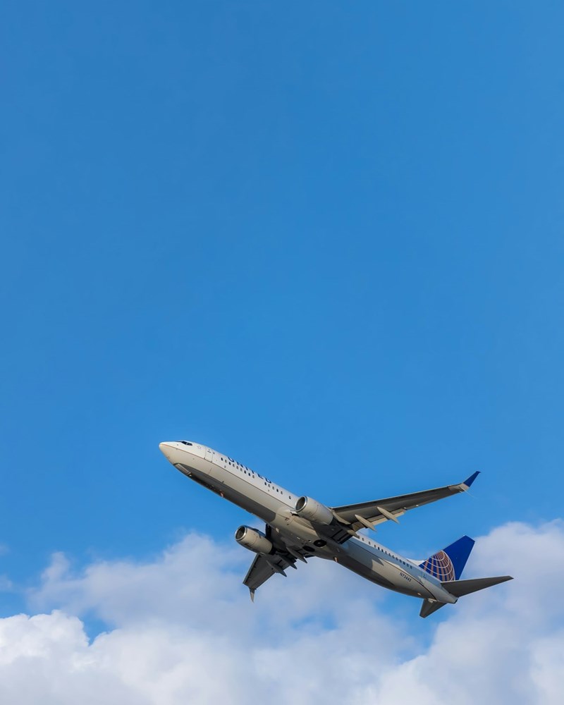 Commercial airplane flying across a clear blue sky