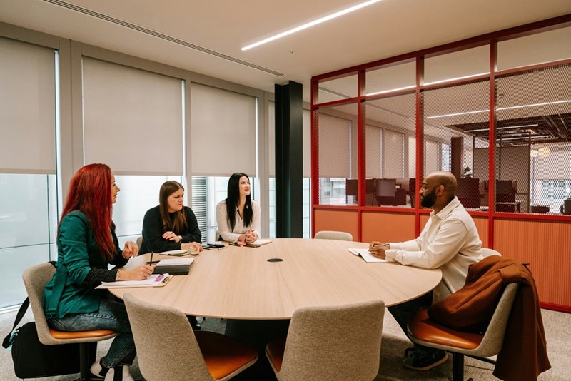 Three employees meet with HR in their office.