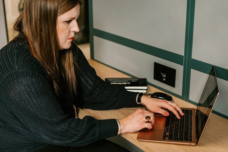 An upset female employee sits at her desk at work, trying to concentrate.