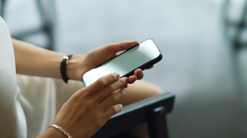 Persons hands holding a phone and touching the screen.