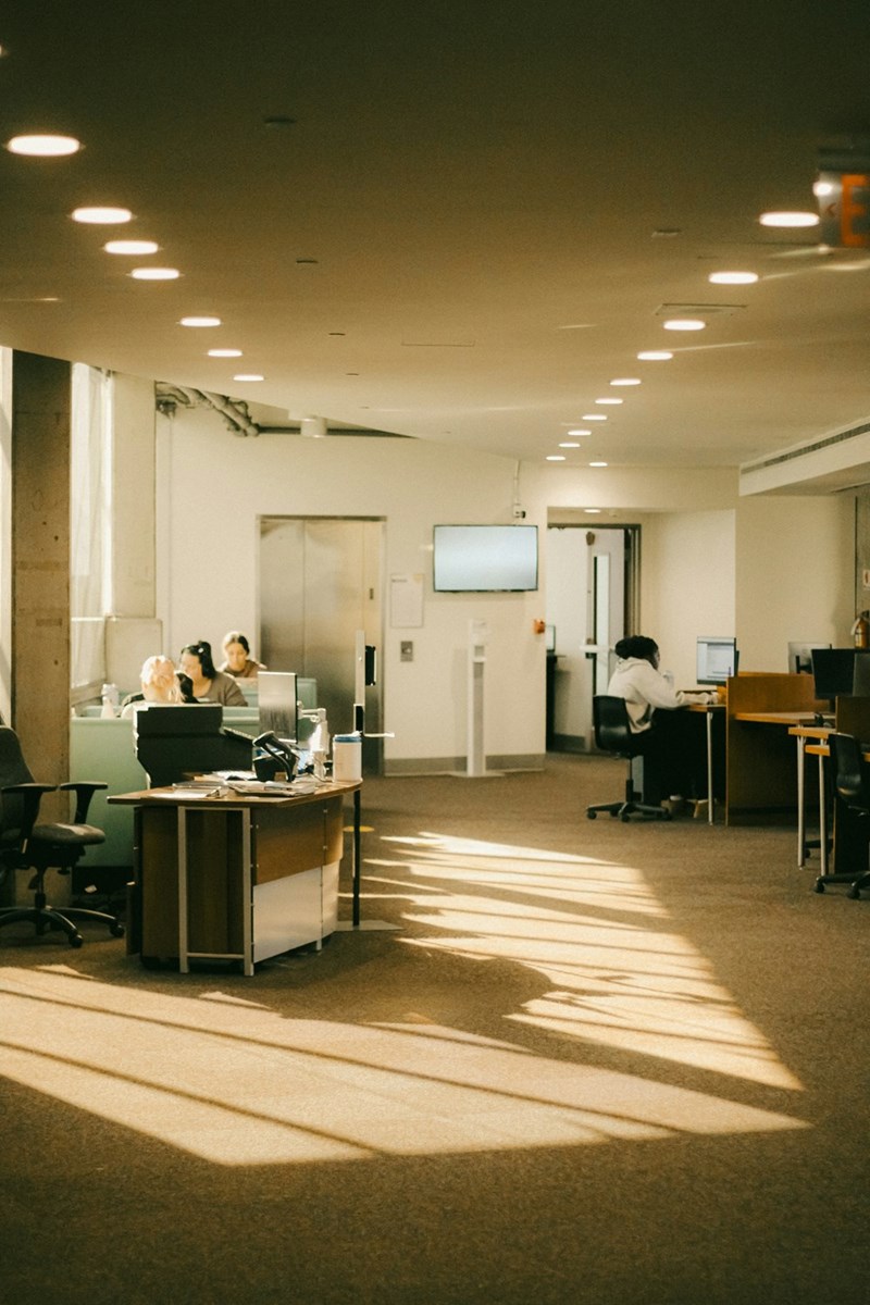 Large open office room with employees working on their computers
