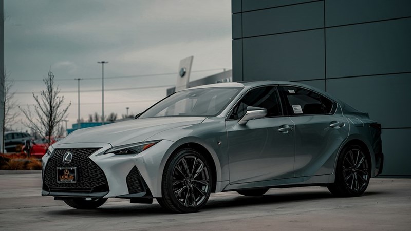 A grey lexus hybrid parked outside a car dealership.
