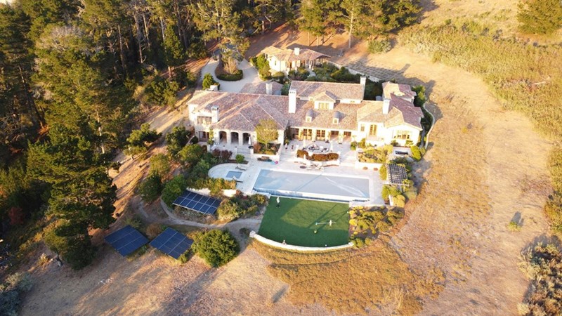 Multi million dollar estate property with a big house and a large tennis court.