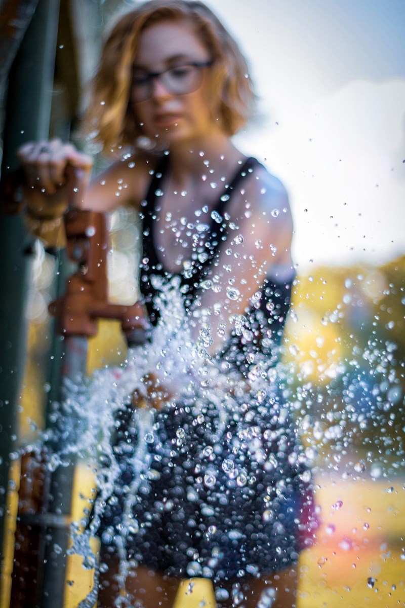 Woman sprays a power washer.